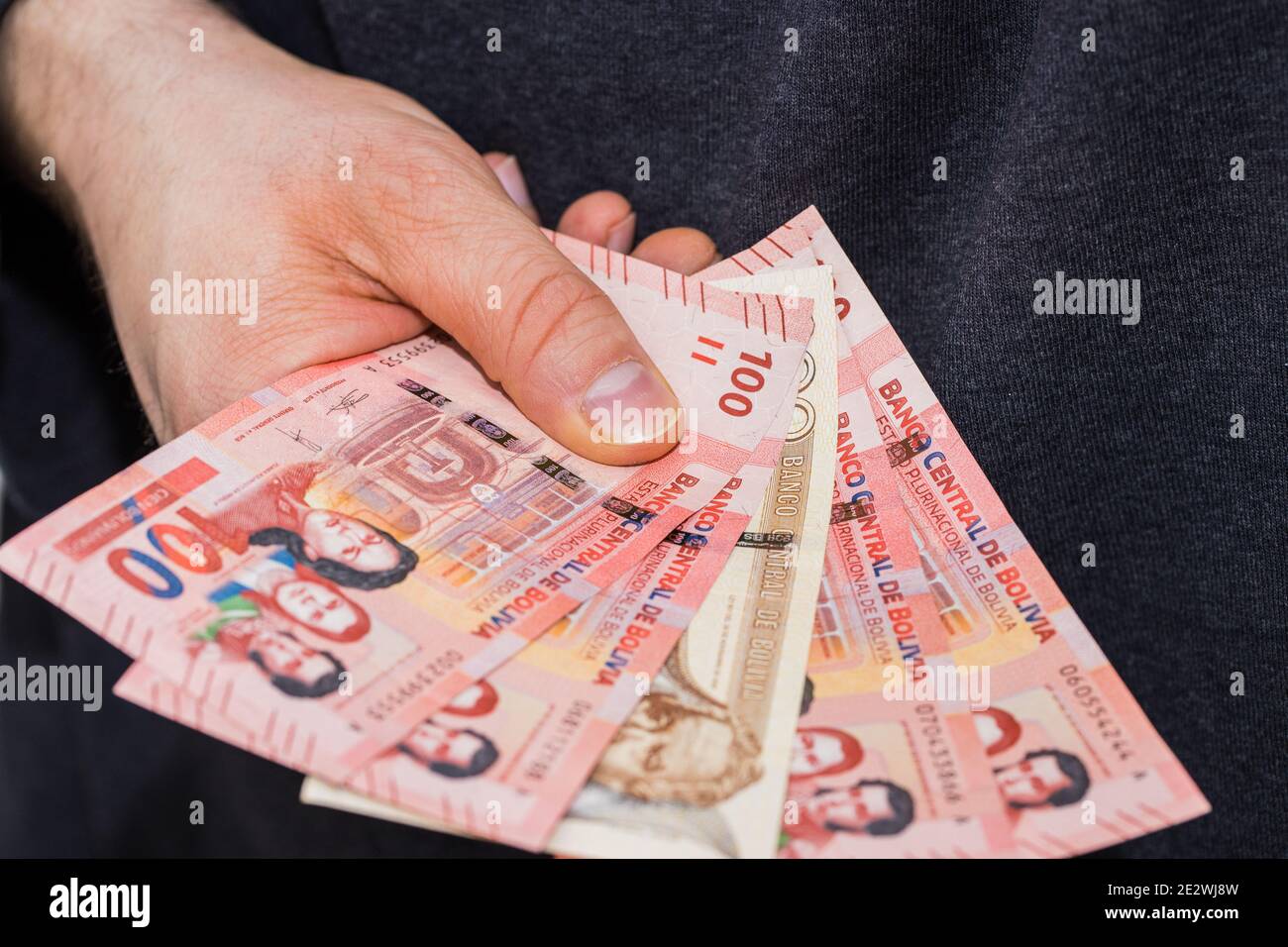 Billets de banque boliviens. L'argent s'est répandu et tenu dans la main Banque D'Images