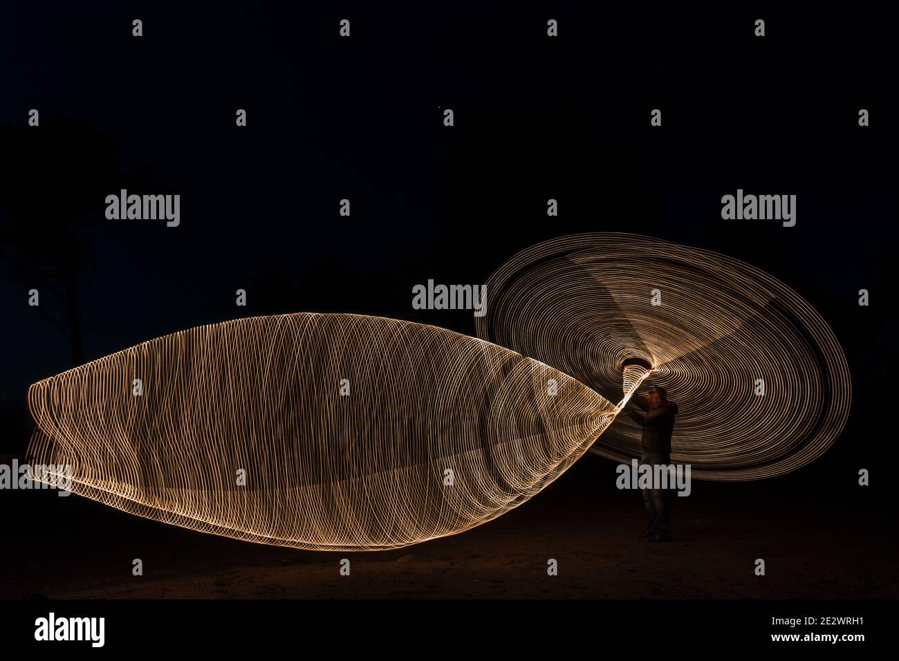 Photo d'un homme qui tourne de la laine d'acier dans l'obscurité Banque D'Images