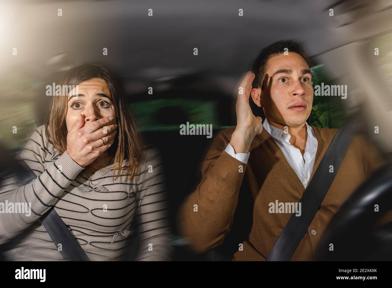 Latino et une femme caucasienne avec des visages effrayés pendant une climatisation de voiture Banque D'Images