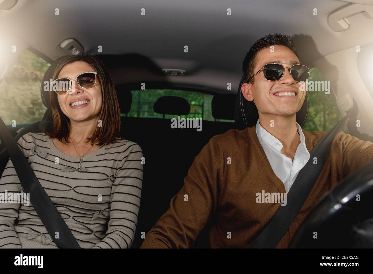 Joyeux couple de Caucasiens en lunettes de soleil voyageant en voiture Banque D'Images