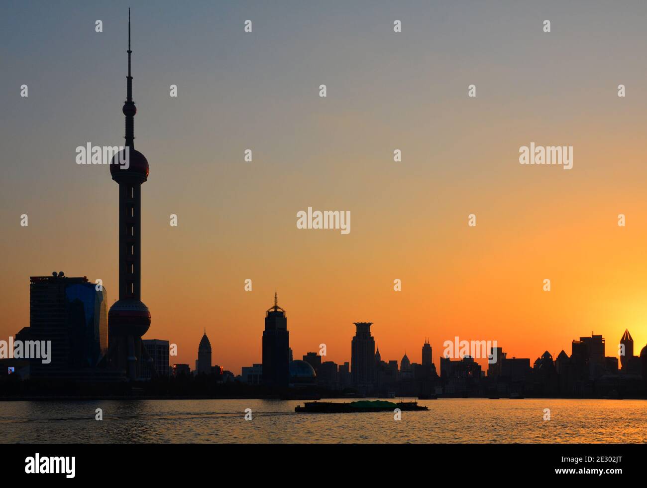 Bateau naviguant seul sur le fleuve Huangpu au coucher du soleil devant le Pudong classique, horizon de Shanghai avec la tour de perle orientale dominante Banque D'Images