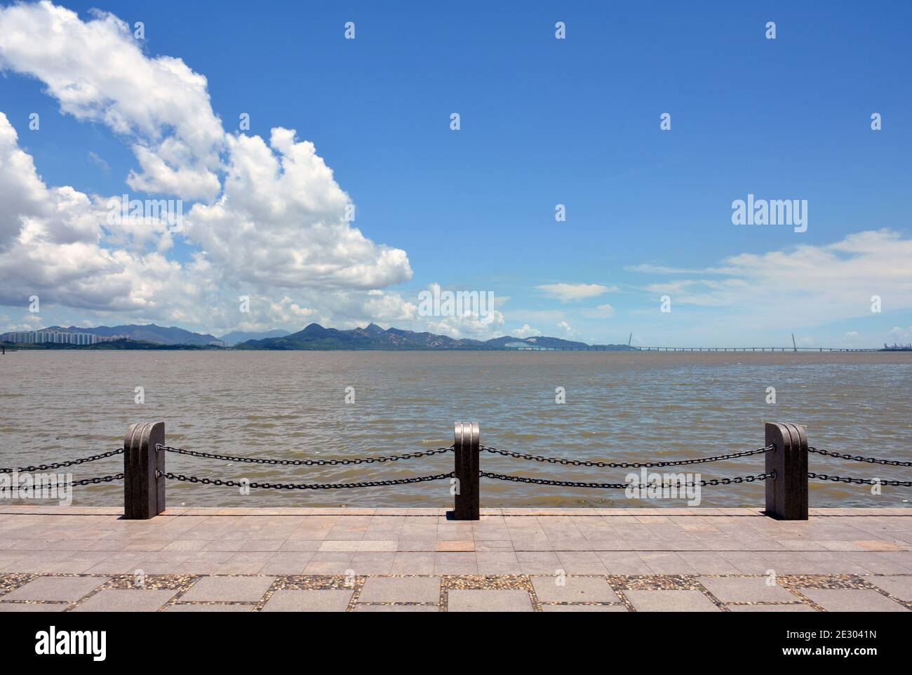 Parc de la baie de Shenzhen et passerelle le long du bord de l'eau. Le pont de la baie de Shenzhen à Hong Kong est au loin. Banque D'Images