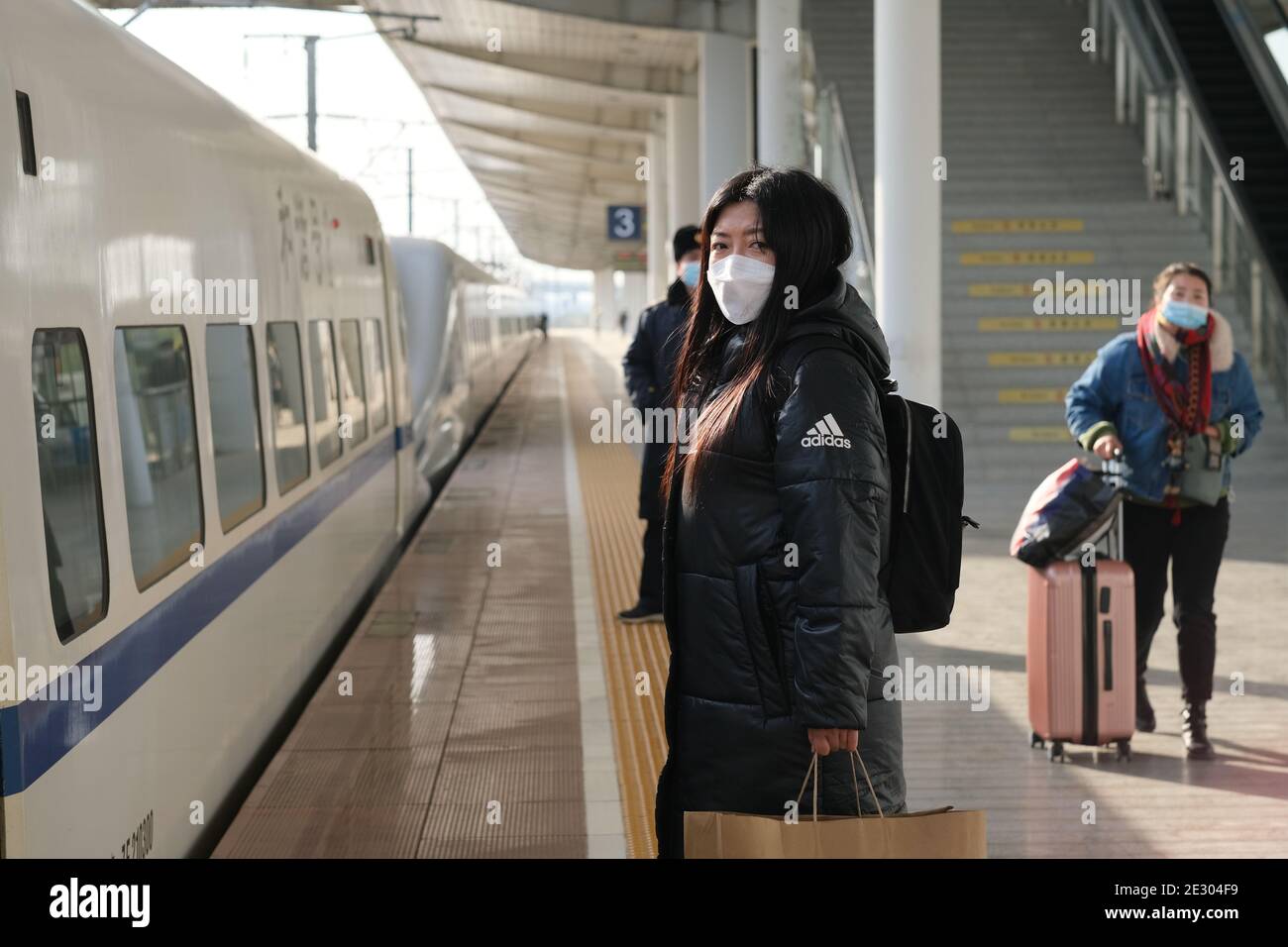 Suzhou.China-Jan.2021: Photo de mi-journée du voyageur chinois sur la plate-forme de la gare, dans le masque facial pour empêcher le coronavirus pendant le Festival de printemps Banque D'Images