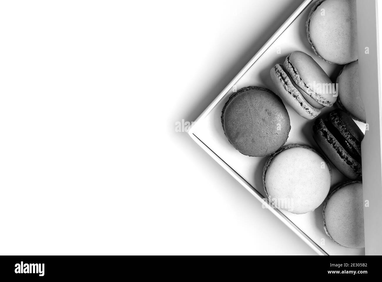 petits macarons dans la boîte avec espace de copie noir et style blanc Banque D'Images