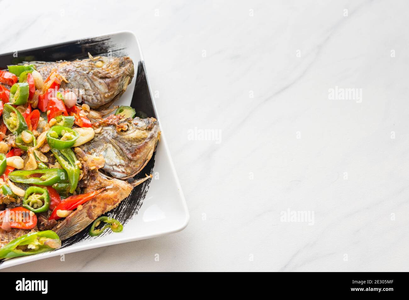 Poisson entier grillé avec salade épicée, cuisine et cuisine de style asiatique - espace de texte pour ajouter du texte. Banque D'Images