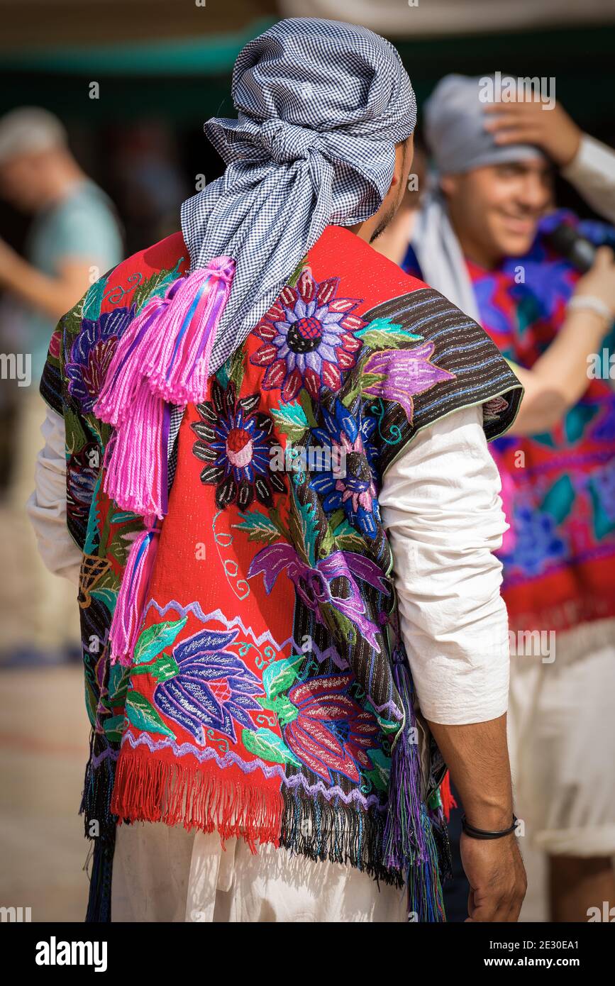 Deux hommes mexicains avec une robe traditionnelle à la texture florale et une coiffure à carreaux avec des glands fuchsia, village de Zinacantan, Chiapas, Mexique. Banque D'Images