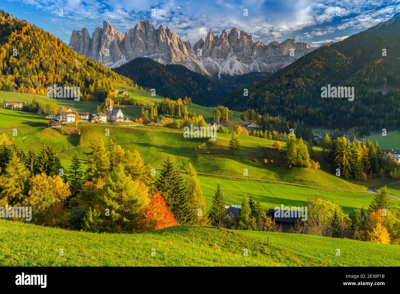 Vue sur un magnifique coucher de soleil sur le massif de l'Odle avec la ville et l'église de Saint-Magdalena. Vallée de Funes, Alpes des Dolomites, Trentin-Haut-Adige, Italie. Banque D'Images