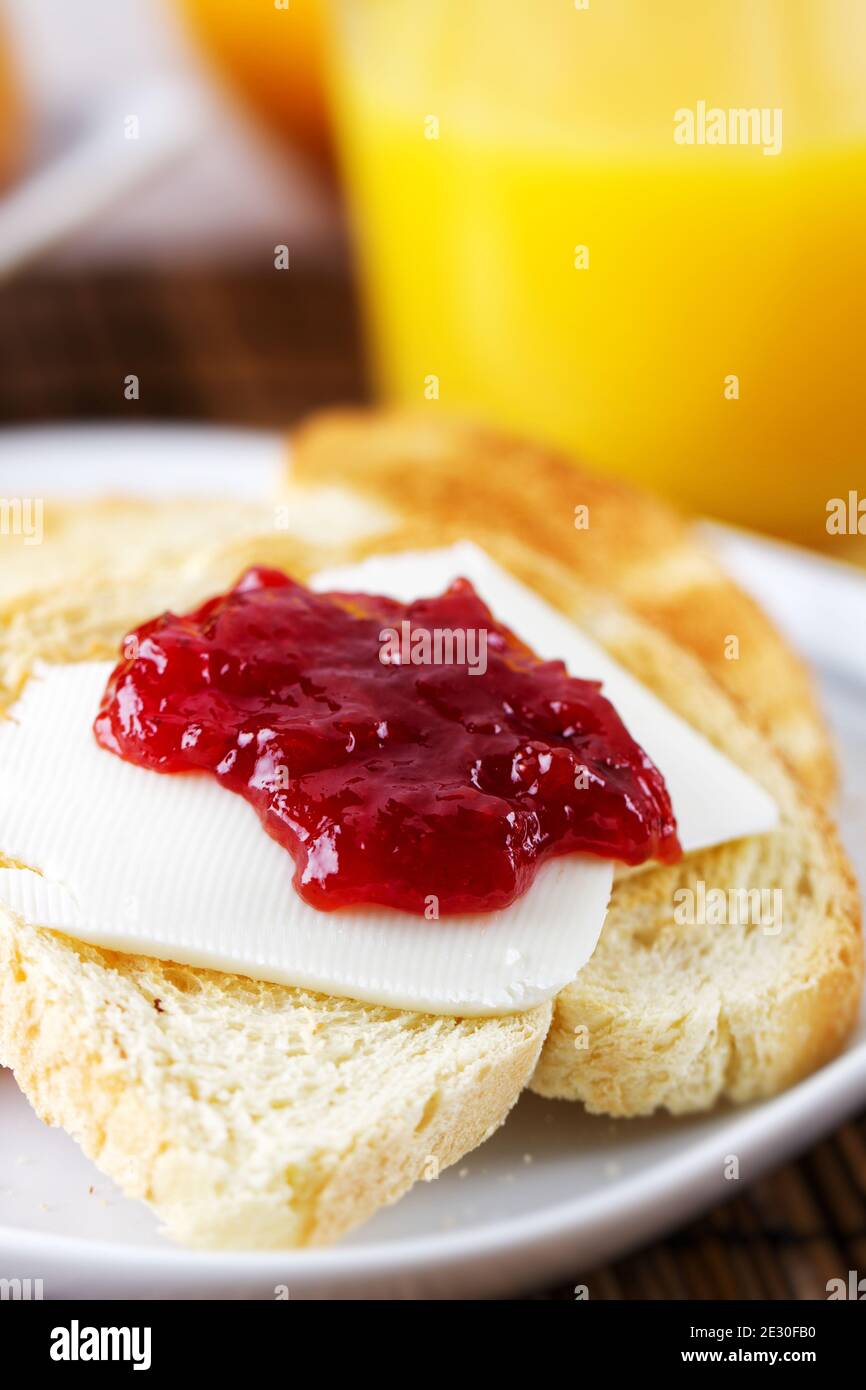 Pain grillé avec du beurre et de la confiture de fraise sur un fond blanc  Photo Stock