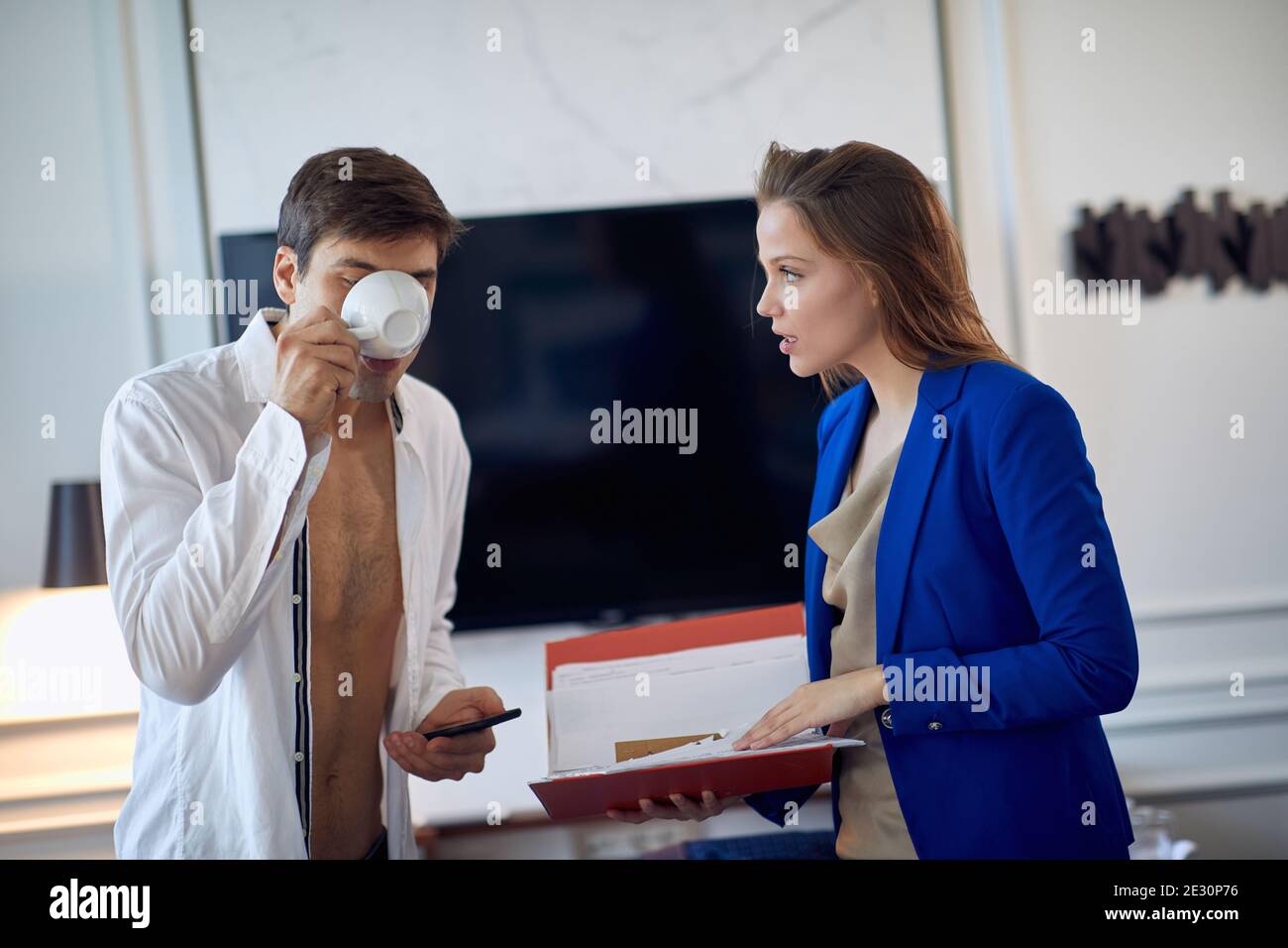 Un jeune couple dans la chambre d'hôtel est pressé de se rencontrer lors de son voyage d'affaires le matin d'une belle journée. Hôtel, affaires, personnes Banque D'Images