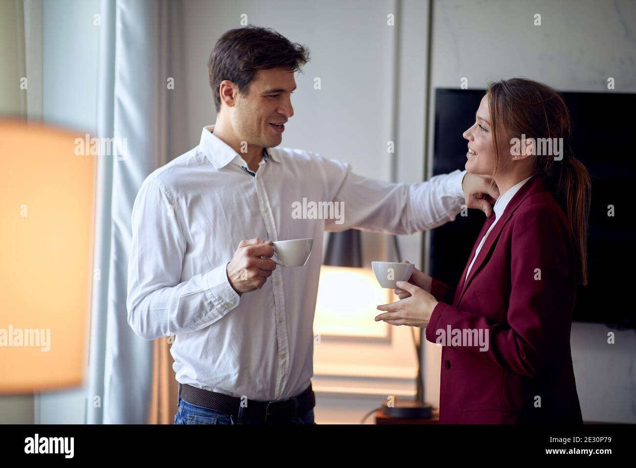 Un jeune couple qui profite d'un café et de moments ensemble à l'hôtel lors de son voyage d'affaires le matin d'une belle journée. Hôtel, affaires, personnes Banque D'Images