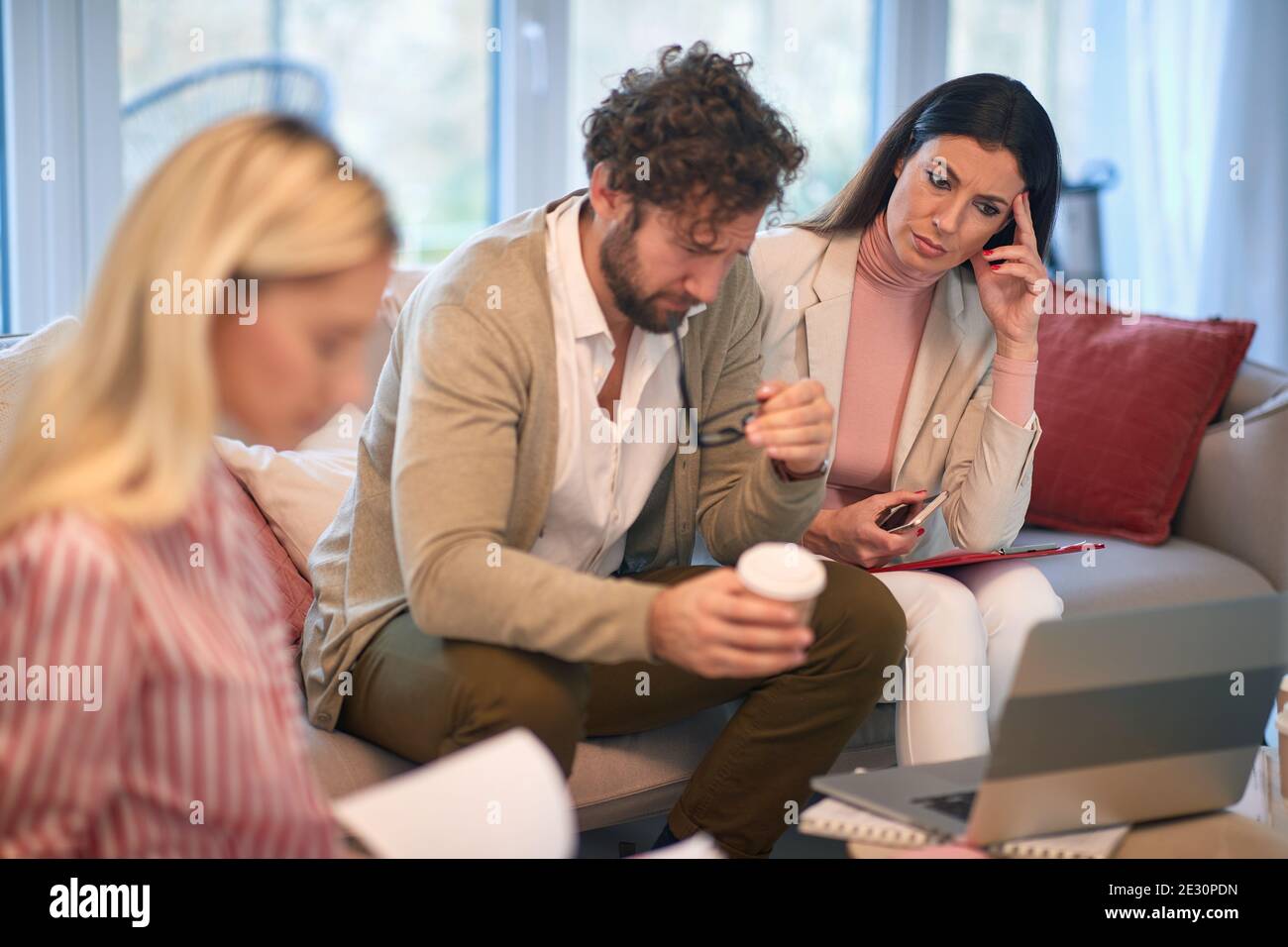 Un groupe de jeunes gens d'affaires lors d'une réunion dans une atmosphère tendue inquiet des résultats d'affaires. Personnes, affaires, réunion Banque D'Images