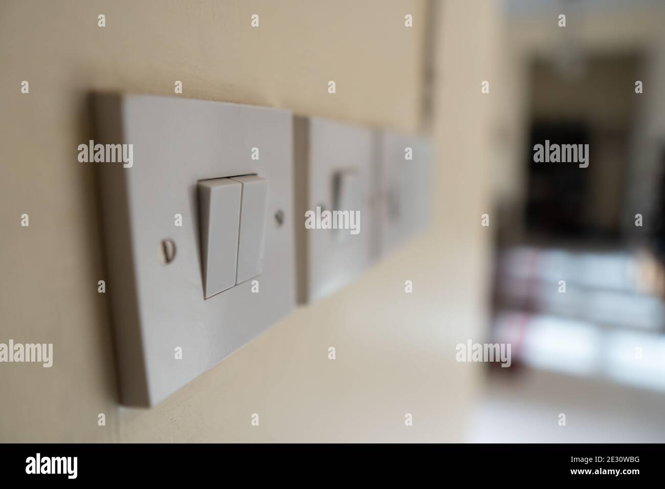 Une série simple d'interrupteurs électriques blancs sur un mur blanc à l'intérieur d'une maison. Concepts de construction industrielle, résidentielle ou de bricolage. Focu sélectif Banque D'Images