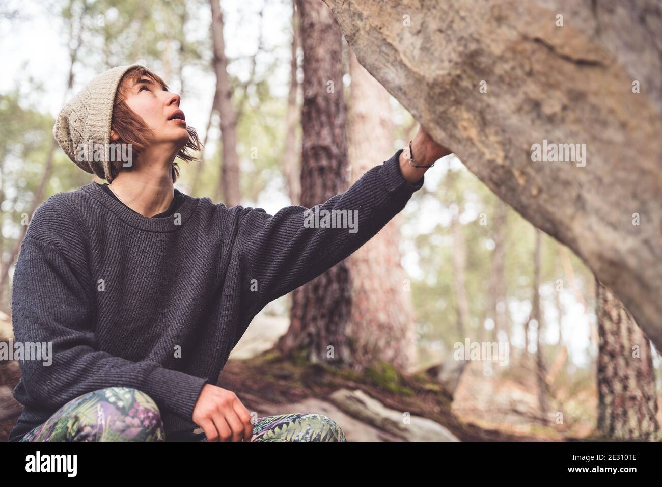 Une femme grimpeur se préparant à se débouler sur les rochers La forêt de Fontainebleau Banque D'Images
