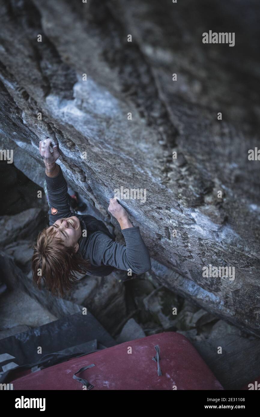 Une femme grimpeur montrant sa détermination en bloc sur le granit à Brione, Swizterland Banque D'Images