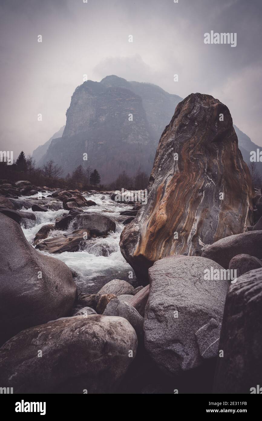 Un magnifique rocher aux coutures orange et gris, situé le long de la rivière Verzasca dans les Alpes suisses. Banque D'Images