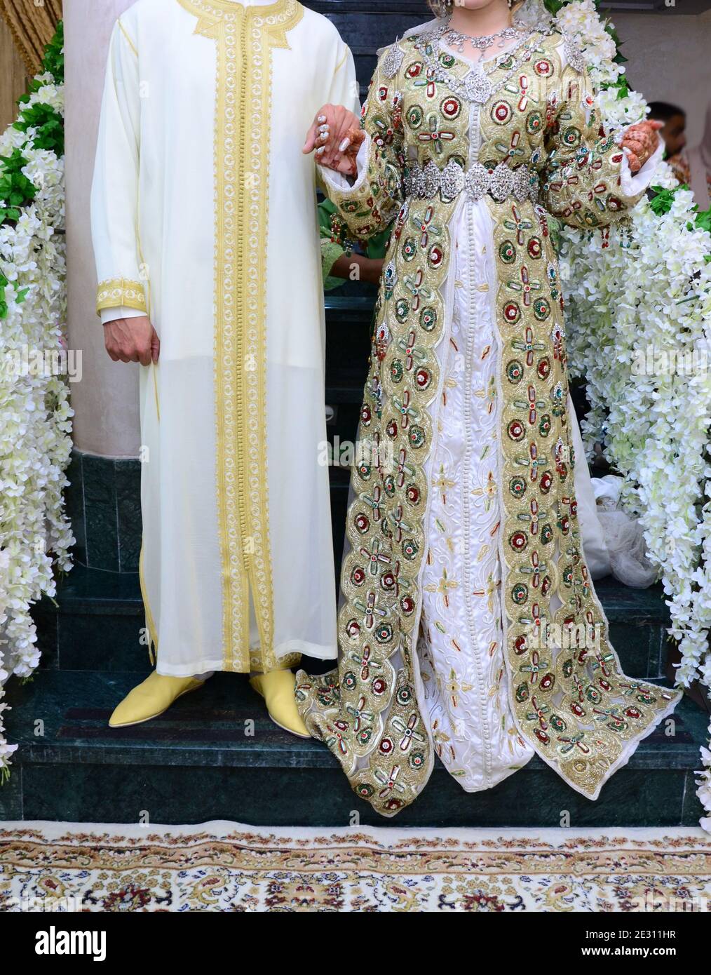 Mariage marocain. Le marié porte la jellaba marocaine. Il tient entre les  mains de la mariée qui porte le caftan MAROCAIN Photo Stock - Alamy
