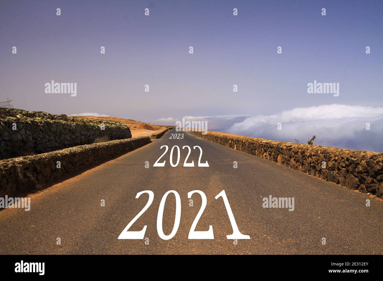 Voir sur une route sans fin au-dessus des nuages avec des nombres d'années de disparition 2021, 2022 et 2023 - concept de perspective d'avenir Banque D'Images