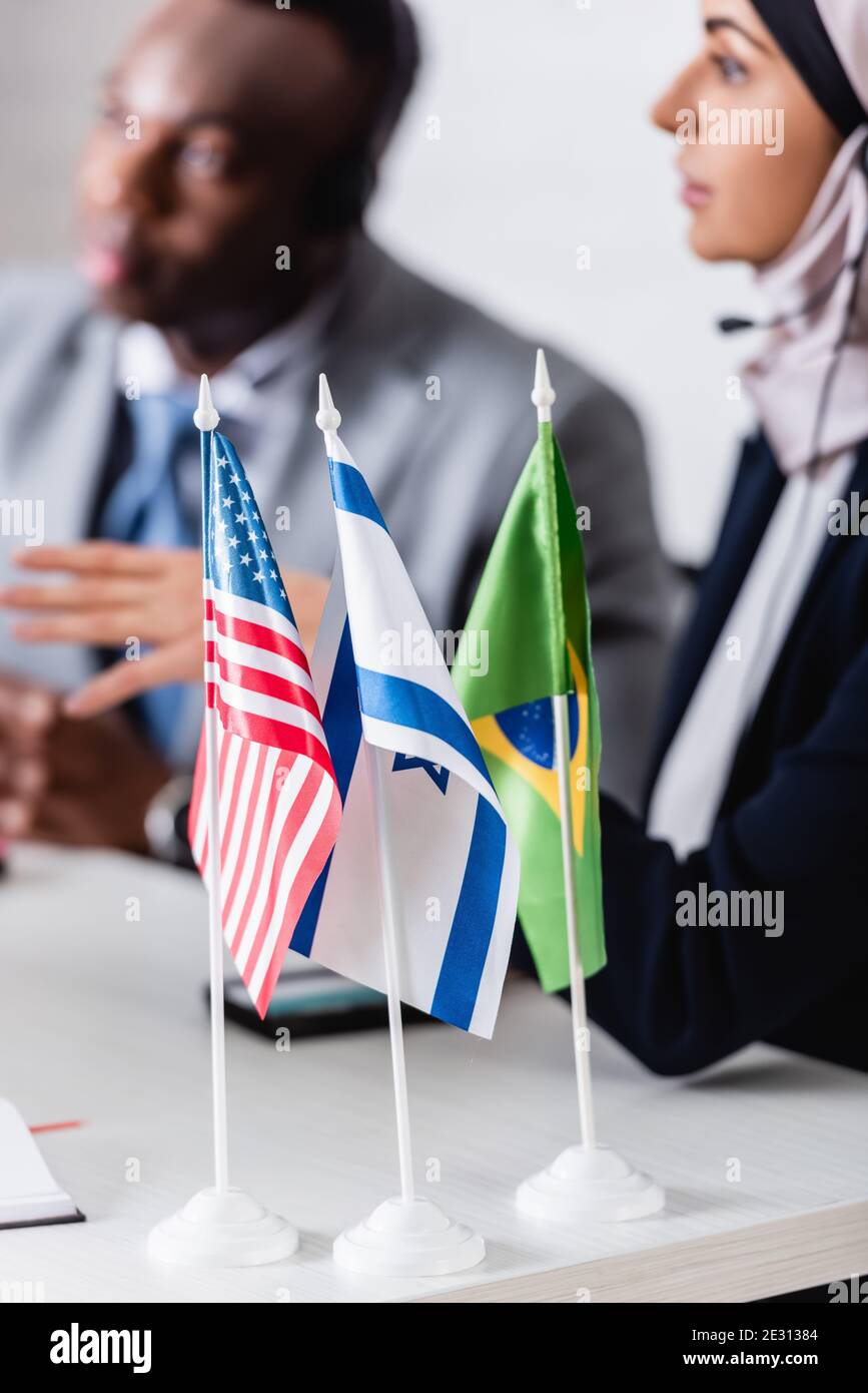 attention sélective aux drapeaux américains, israéliens et brésiliens près des partenaires d'affaires arabes et africains américains sur fond flou Banque D'Images