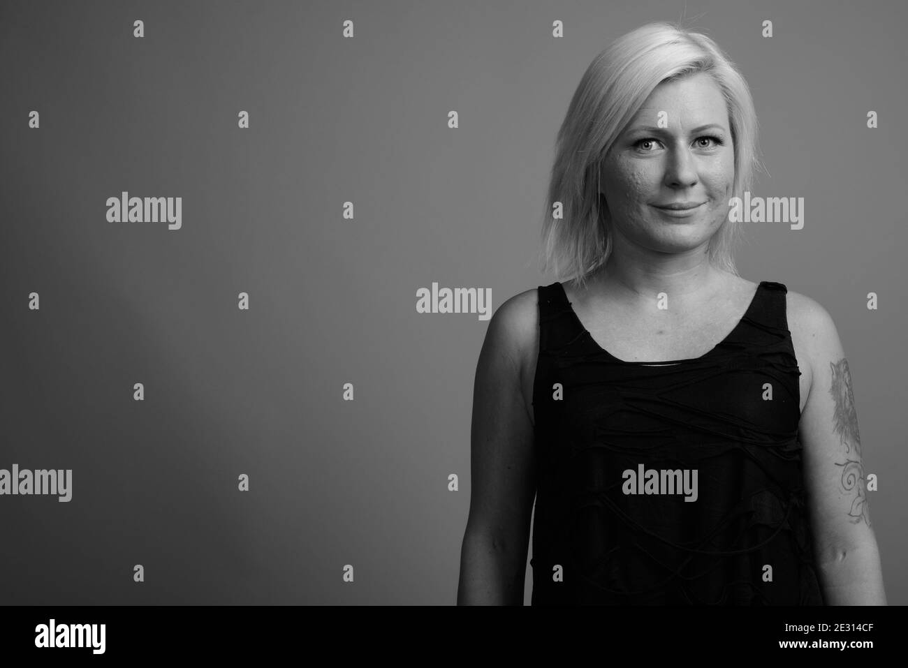 Femme aux cheveux blonds sur fond gris Banque D'Images