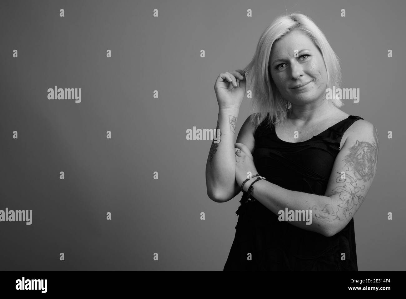 Femme aux cheveux blonds sur fond gris Banque D'Images