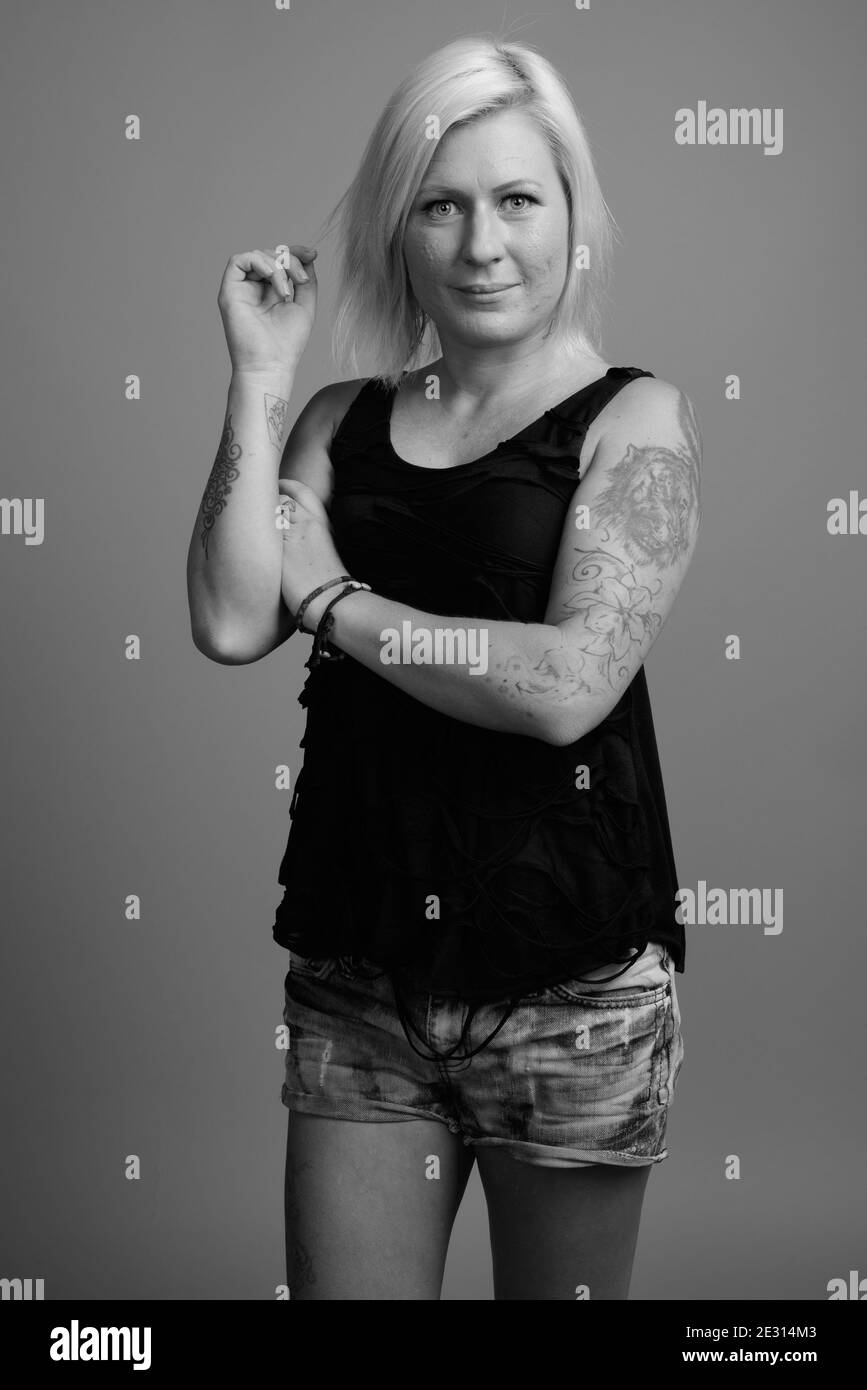 Femme aux cheveux blonds sur fond gris Banque D'Images