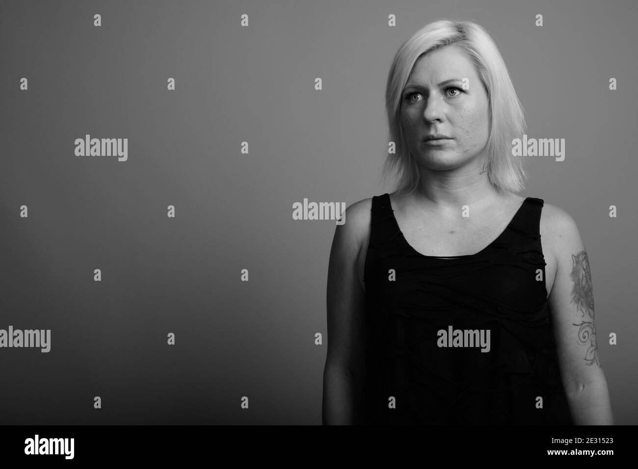 Femme aux cheveux blonds sur fond gris Banque D'Images