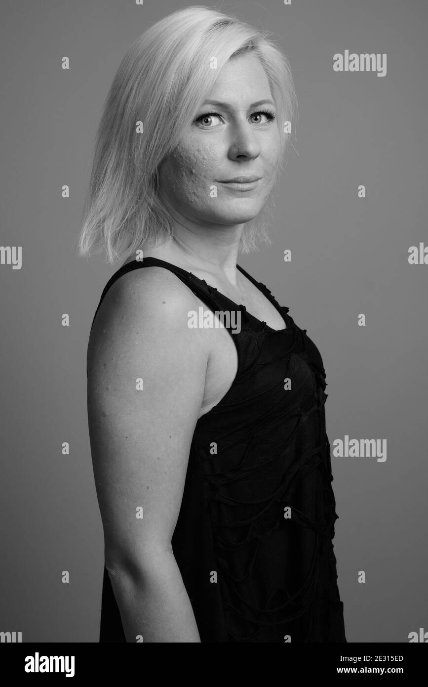 Femme aux cheveux blonds sur fond gris Banque D'Images