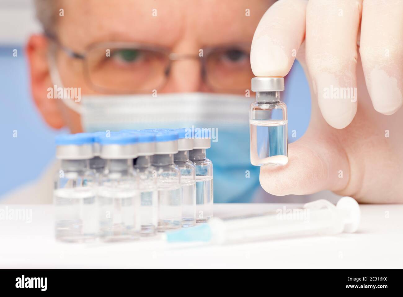 Médecin ou scientifique tenant un flacon contenant un vaccin contre le covid-19 ou la grippe dans sa main - se concentrer sur le flacon Banque D'Images