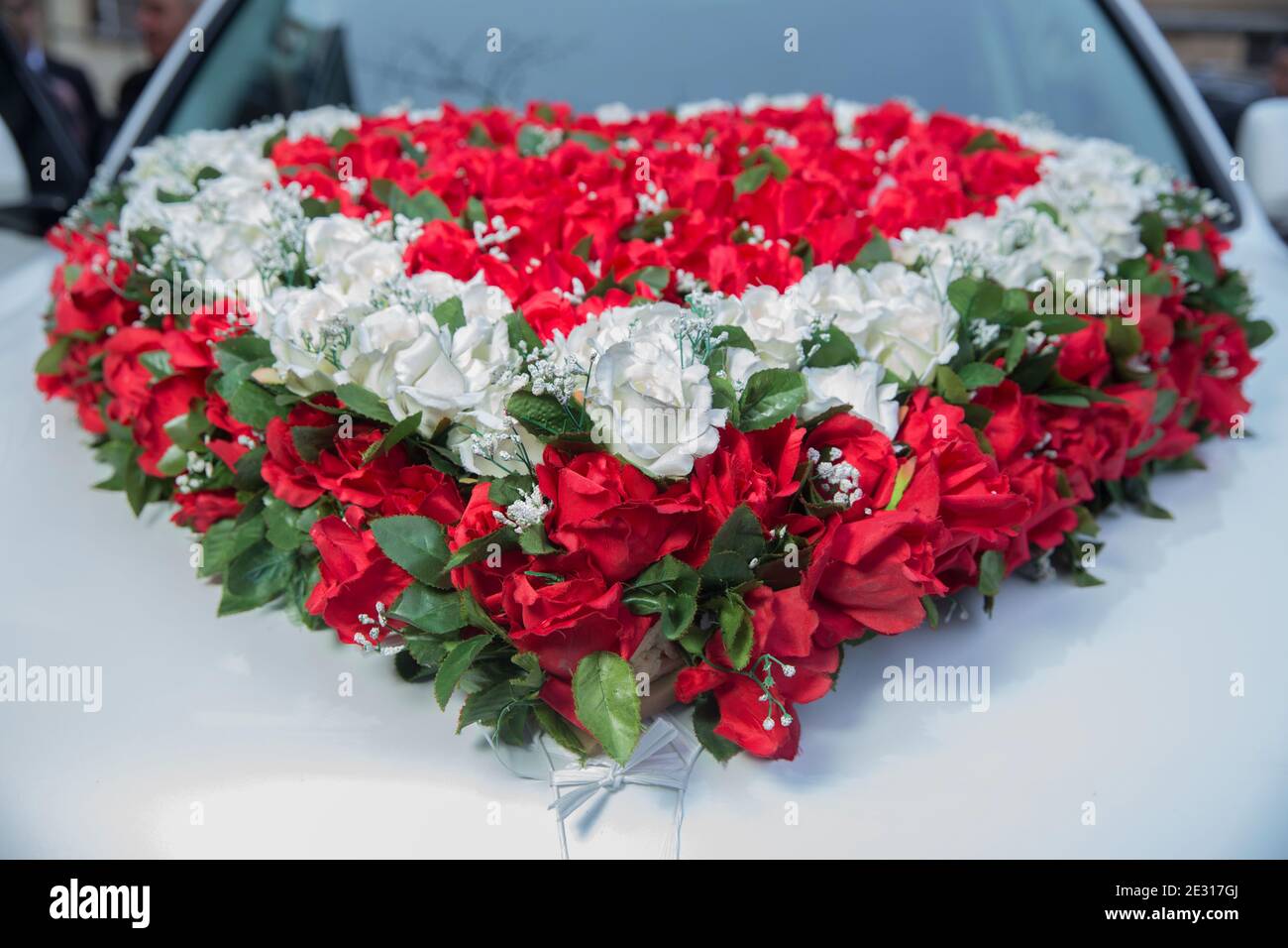 Bouquet de coeur blanc et rouge sur voiture de mariée blanche. Voiture de  mariage et pétales sur le dessus. Voiture de mariage de luxe décorée de  fleurs. Voiture de mariage et pétales