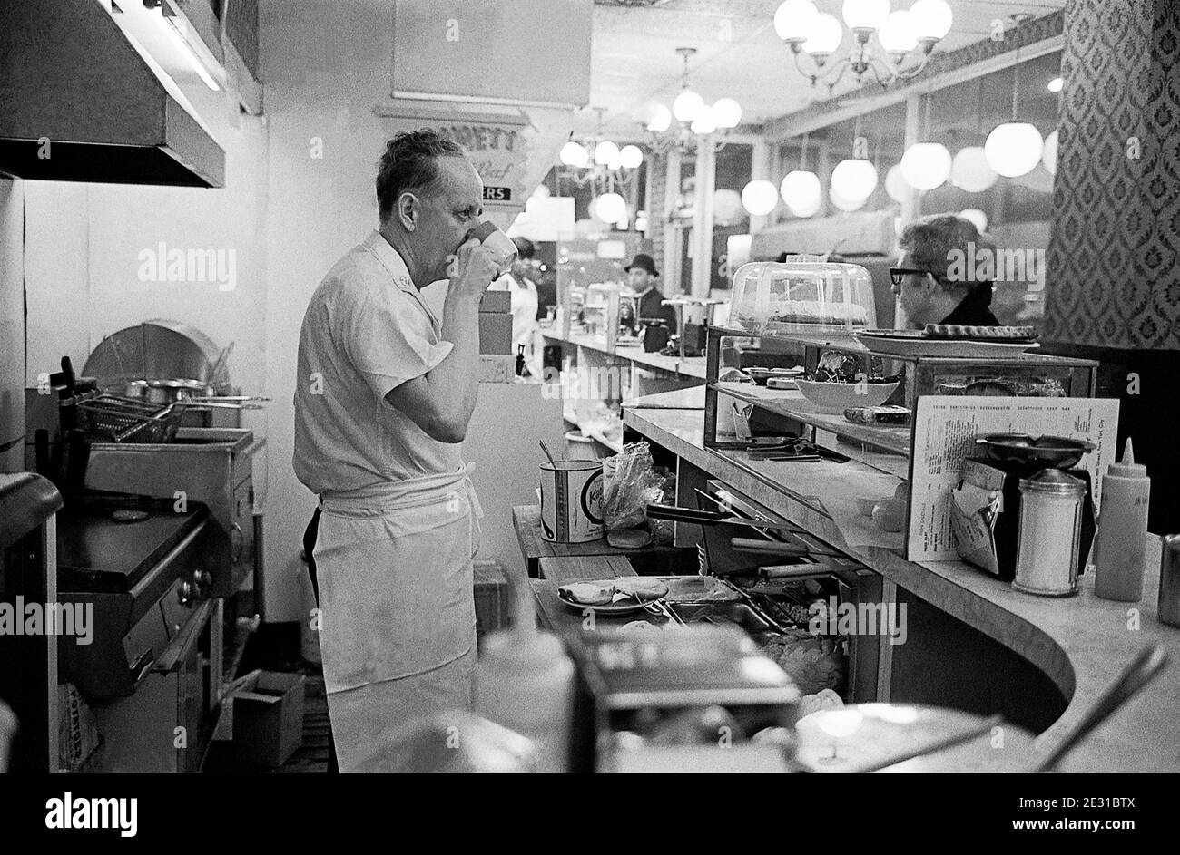 NEW YORK USA le chef d'un grill br boissons une tasse de café derrière le comptoir Banque D'Images