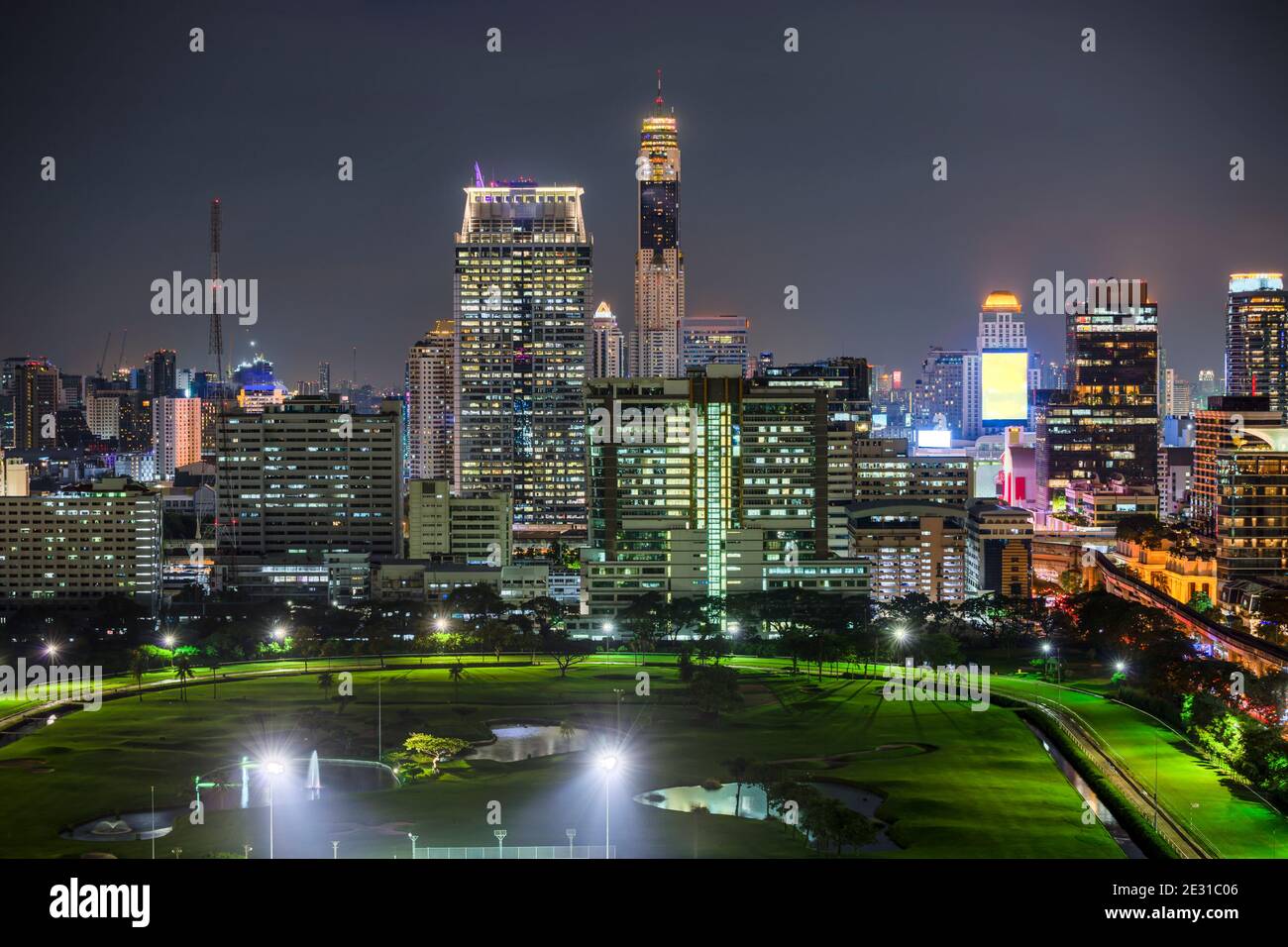 Le quartier des affaires de Bangkok avec le parc public et le train aérien en premier plan à l'heure du coucher du soleil. Banque D'Images