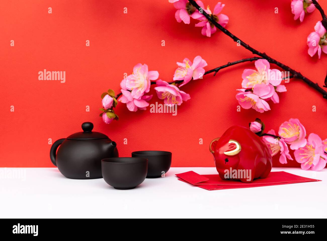 Année de l'Ox Piggy Bank, sakura Cherry Blossom, Black Chinese Teapot et Red Envelope Angpow sur blanc et Red Chinese New Year Backgrounds Banque D'Images