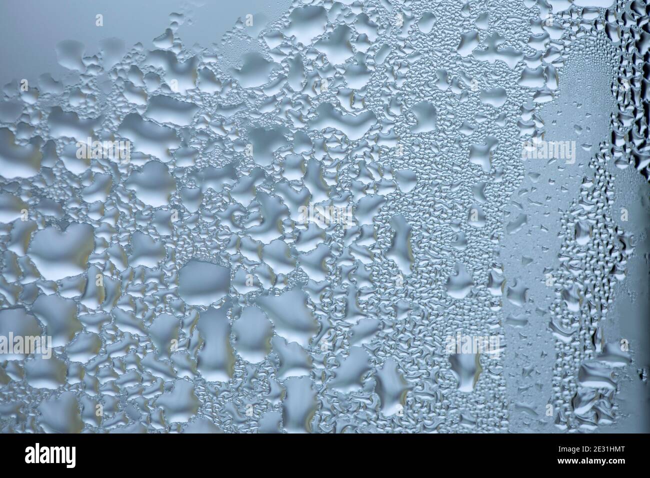 Gouttes d'eau sur le verre, motif abstrait. Condensation de vapeur sur la fenêtre, hiver. Banque D'Images