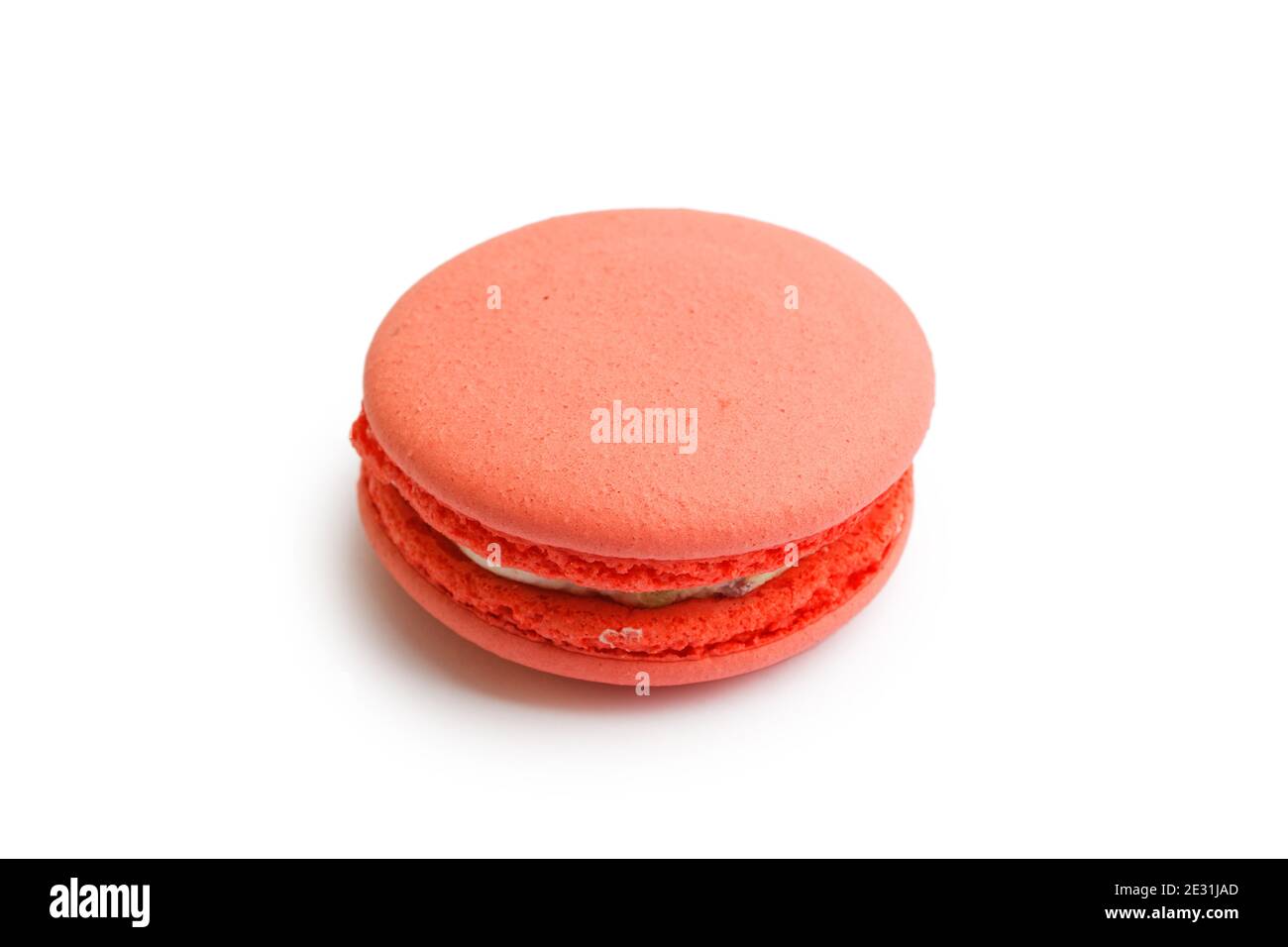 Gros plan macaron rouge isolé sur blanc avec ombre. Vue en angle. Banque D'Images