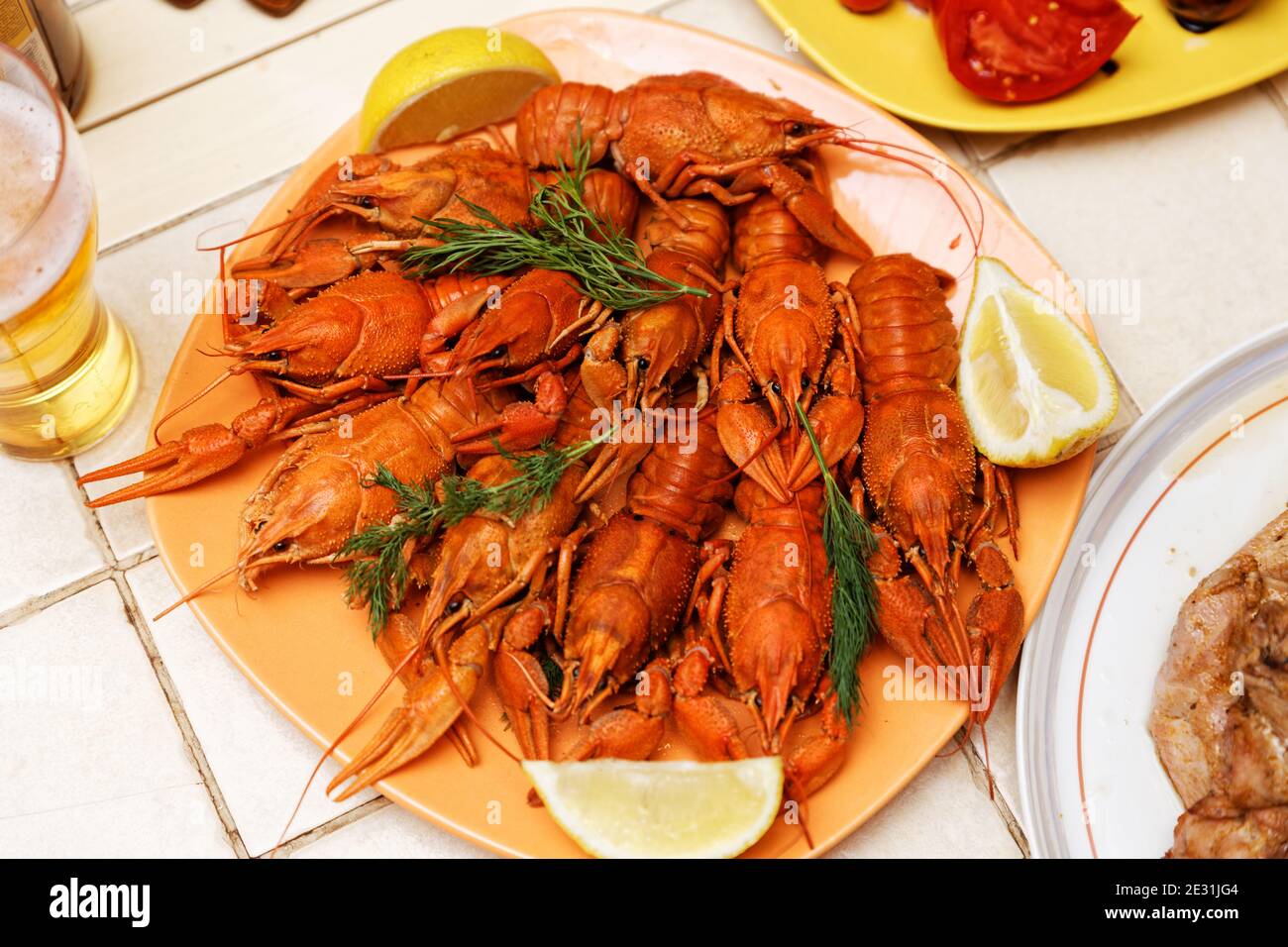 Écrevisse bouillie rouge avec des tranches de citron sur la table. Mise au point peu profonde. Banque D'Images Écrevisse bouillie rouge avec des tranches de citron sur la table. Mise au point peu profonde. Banque D'Images