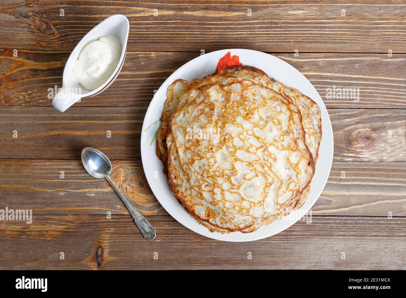 Plat avec crêpes et crème sure sur table en bois. Vue de dessus. Banque D'Images