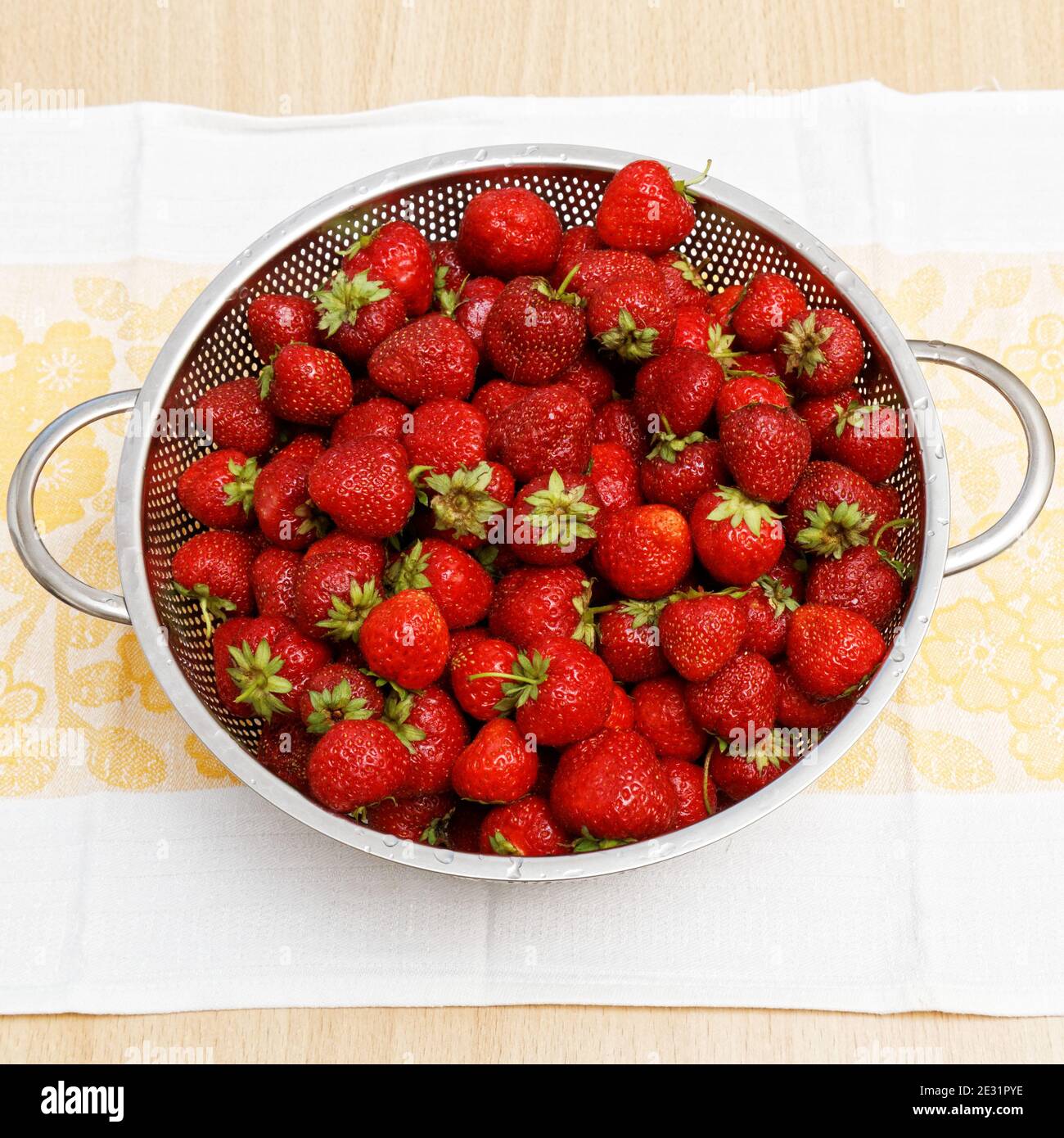 Image d'un grand nombre de fraises fraîchement mûres dans un tamis métallique. Vue de dessus. Banque D'Images