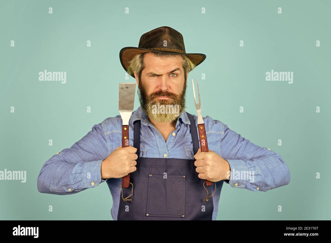 camping. Le défi de la cuisine ultime. Préparez le dîner pour la famille. Utilisez des ustensiles de cuisine et divers produits. Le chef mûr utilise des ustensiles de cuisine pour le barbecue. Outils pour la torréfaction de viande. Qui cuisinent mieux. Banque D'Images