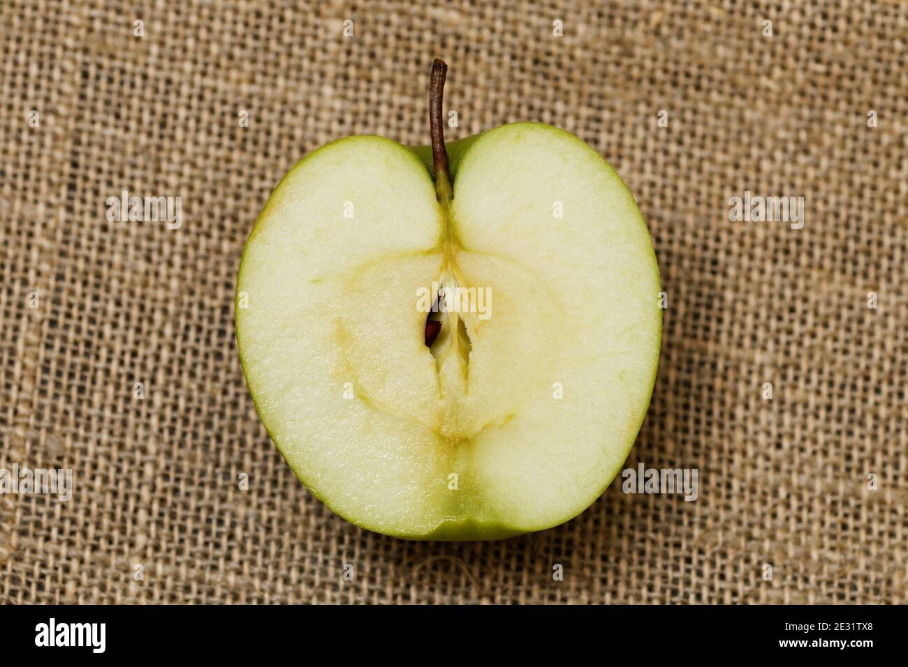 La moitié de la petite pomme verte sur l'emballage Banque D'Images