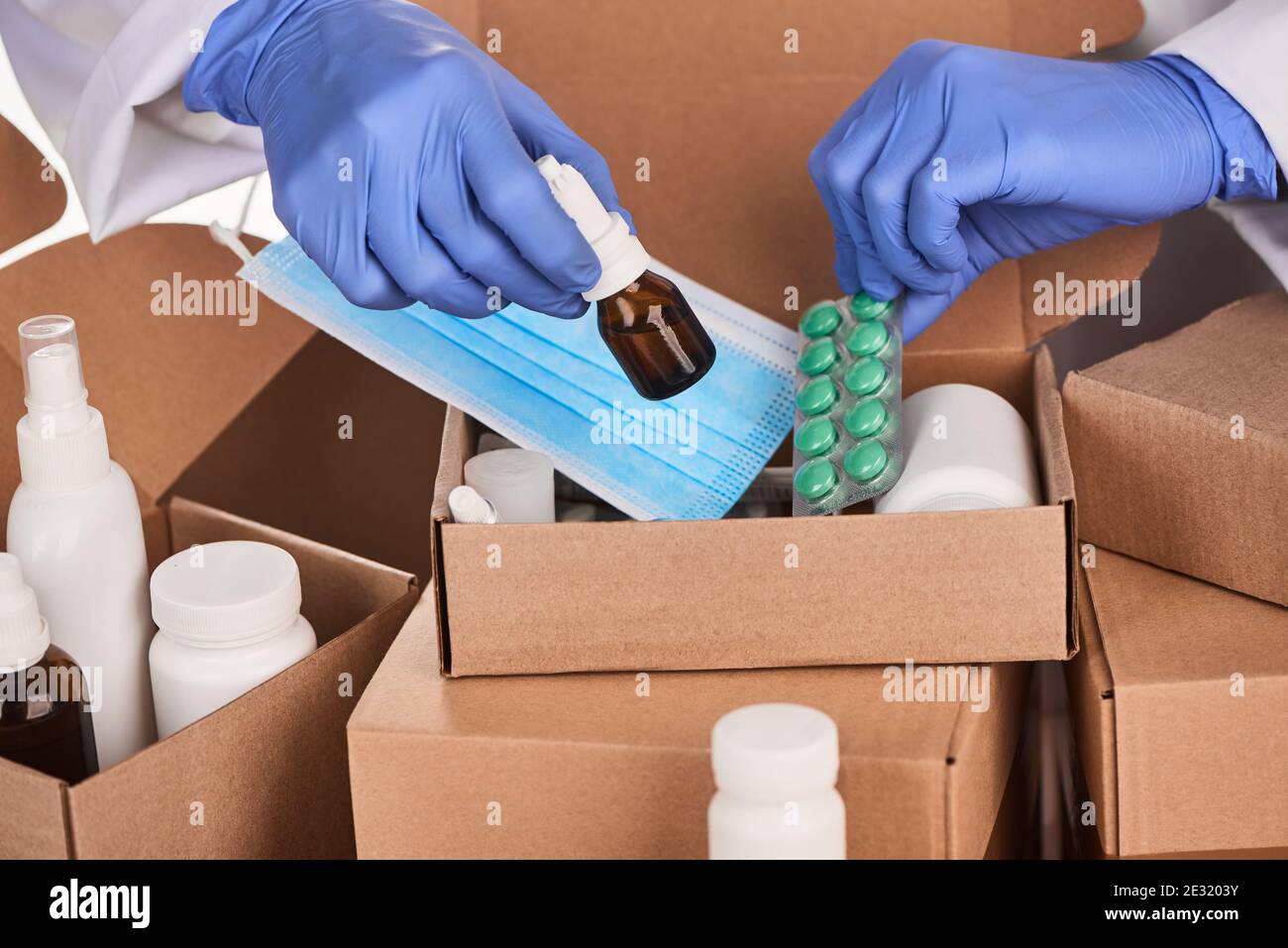 Médecin collectant des ensembles de médicaments prescrits et des fournitures dans des boîtes Banque D'Images