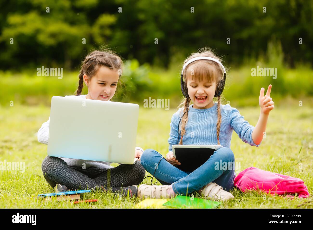 Deux adolescentes. L'été dans la nature. Ils sont assis sur l'herbe. Communiquer les uns avec les autres. Il parle de conversation intime. Meilleurs amis. Confidentialité Banque D'Images