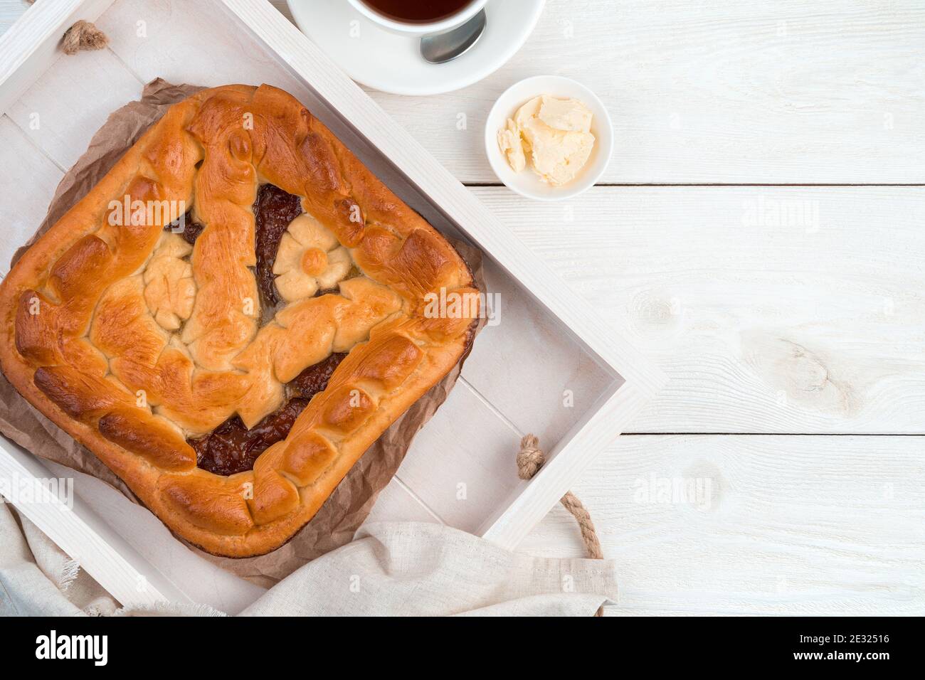 Tarte avec remplissage sur un plateau sur fond en bois clair. Banque D'Images