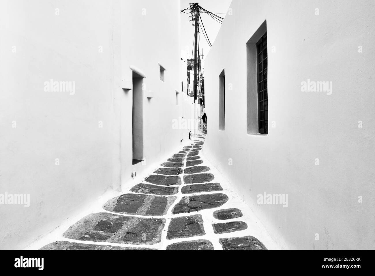 Perspective d'une rue entre les maisons traditionnelles blanchies à la chaux dans la ville de Mykonos (Chora), Grèce. Architecture grecque. Photographie en noir et blanc Banque D'Images