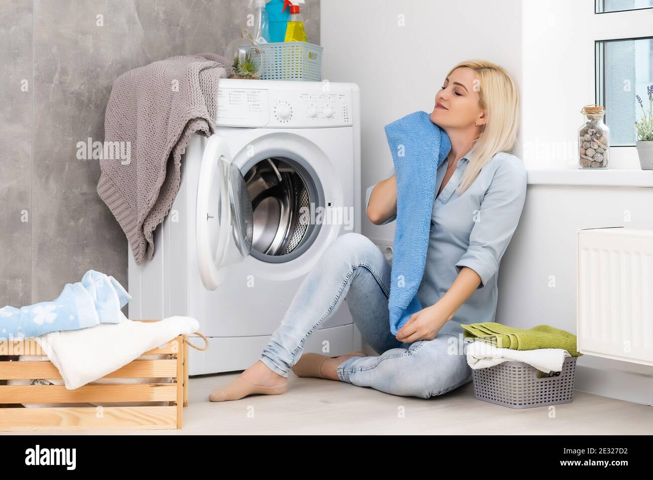 Une jeune femme au foyer avec machine à laver et vêtements. Journée de  lavage Photo Stock - Alamy