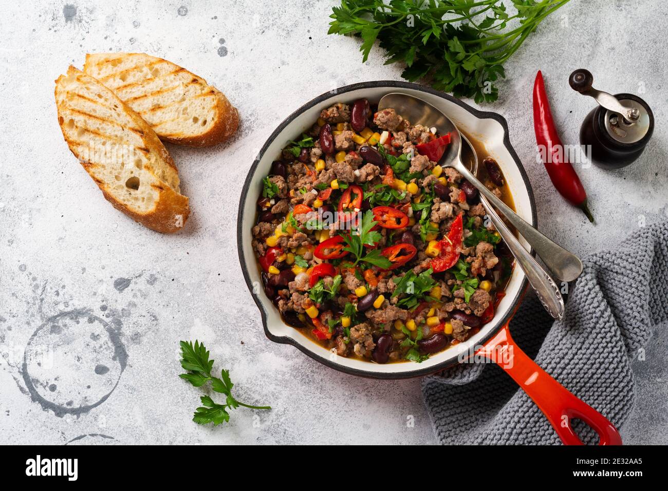 Cuisine mexicaine traditionnelle - Chili con carne avec viande hachée et les légumes ragoût dans la sauce tomate dans une fonte faire une casserole sur un bac en ardoise gris clair ou en béton Banque D'Images