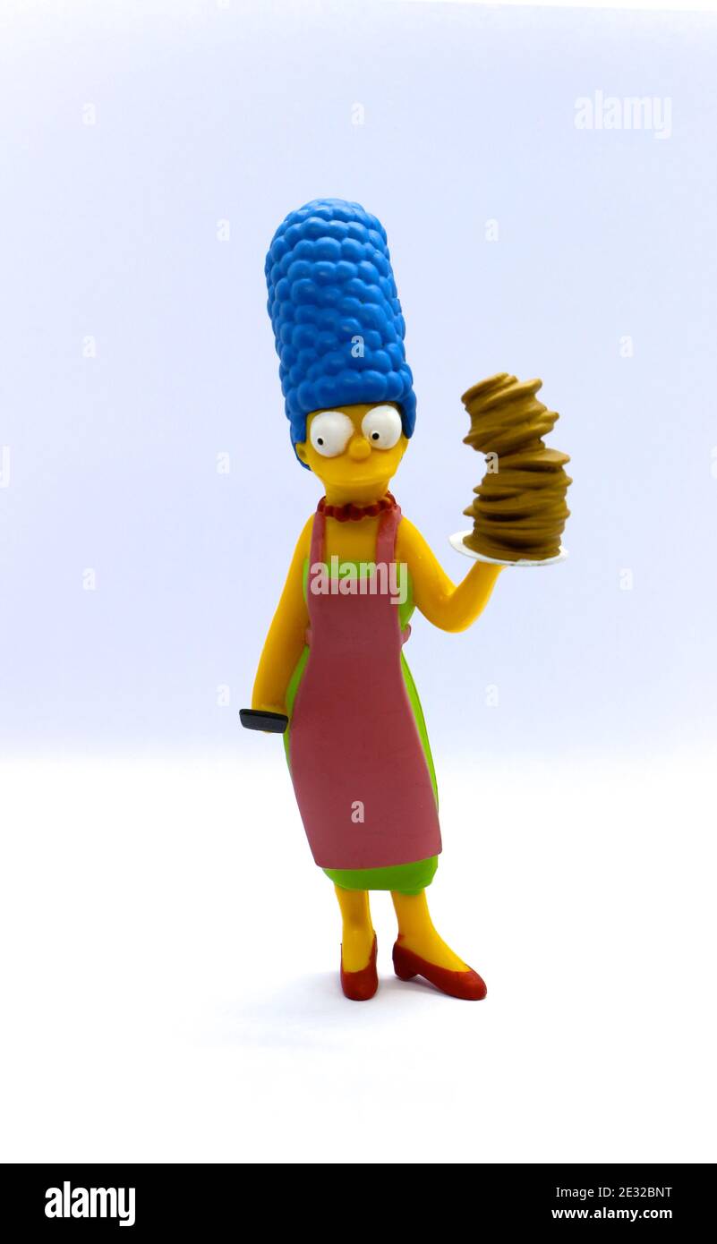 Photo d'un modèle de collectionneurs en céramique de Marge Simpson des Simpsons debout tenant une pile de crêpes sur un fond blanc Banque D'Images