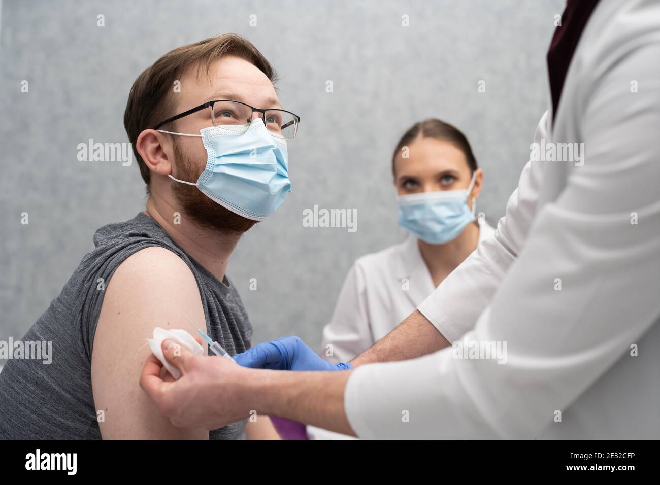 Dans le cabinet d'un médecin, une infirmière injecte un jeune patient avec les vaccins COVID19. Une injection avec une nouvelle formule vaccinale pour soutenir le corps et augmenter la résistance aux maladies infectieuses. Banque D'Images
