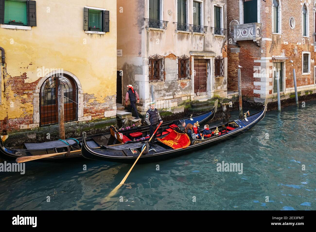 Gondole vénitienne traditionnelle avec des touristes sur un canal dans la sestière de Dorsoduro, Venise, Italie Banque D'Images