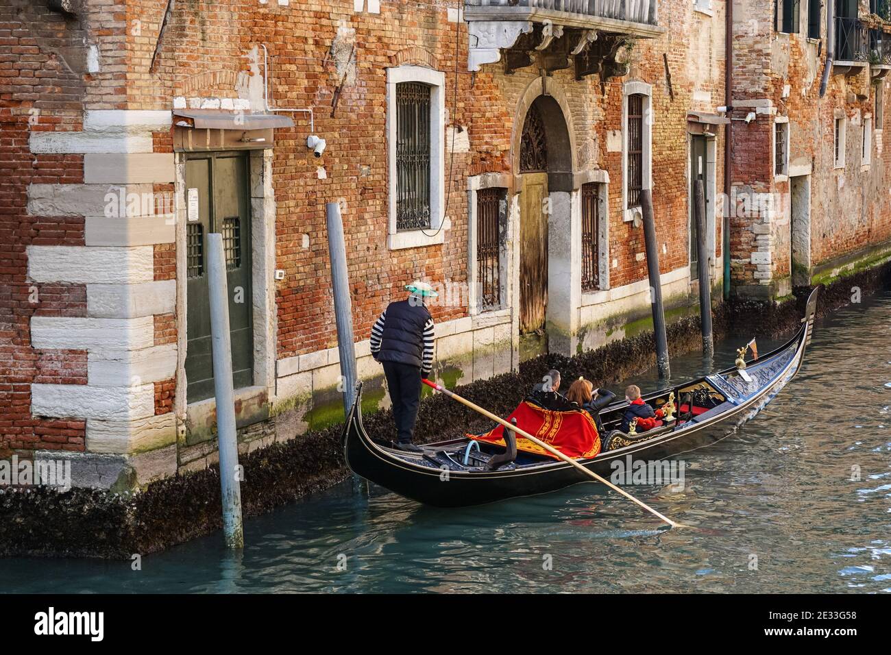 Gondole vénitienne traditionnelle avec des touristes sur un canal dans la sestière de Dorsoduro, Venise, Italie Banque D'Images