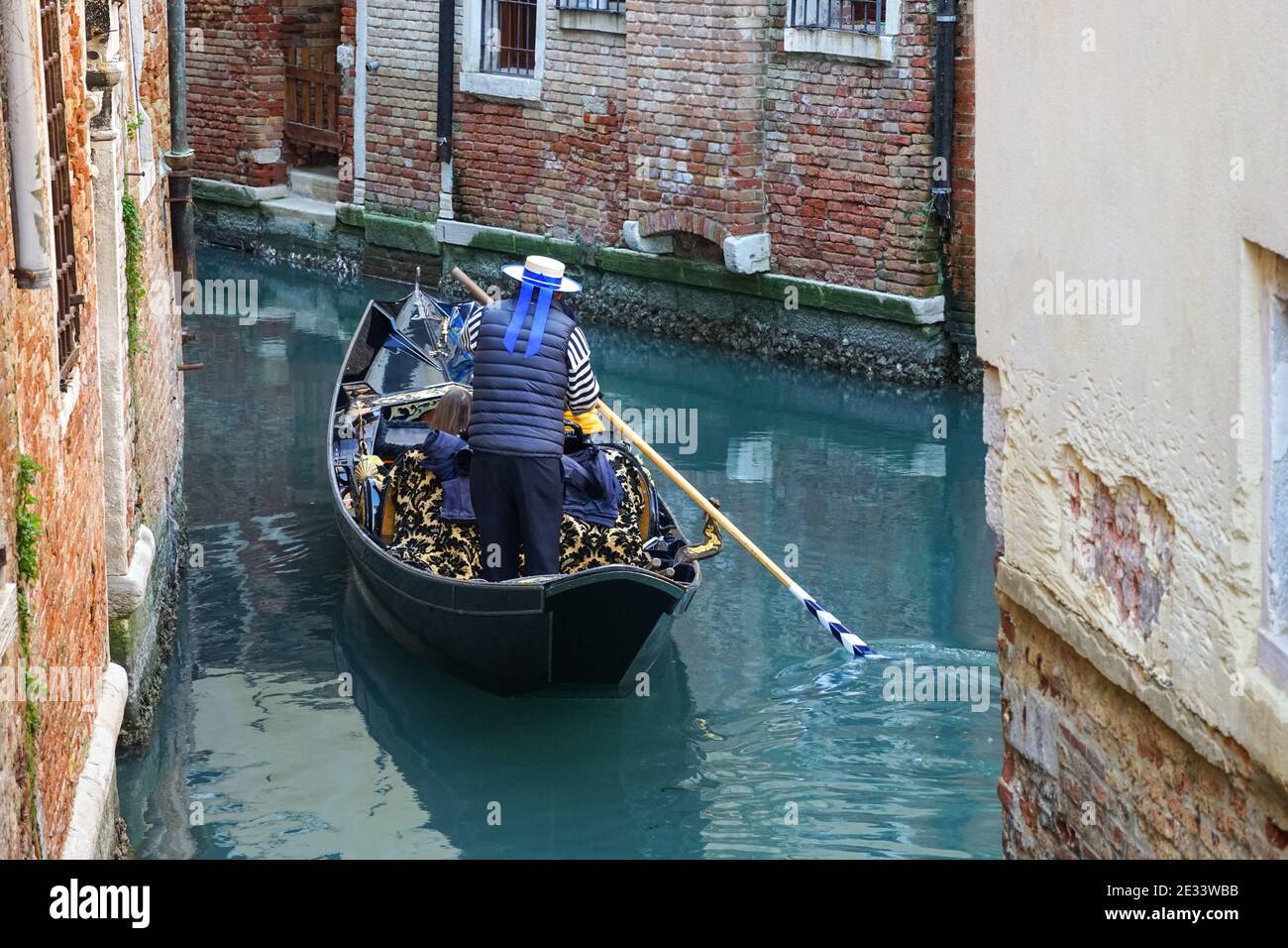 Gondolier sur une gondole vénitienne traditionnelle avec des touristes sur le canal à Venise, Italie Banque D'Images